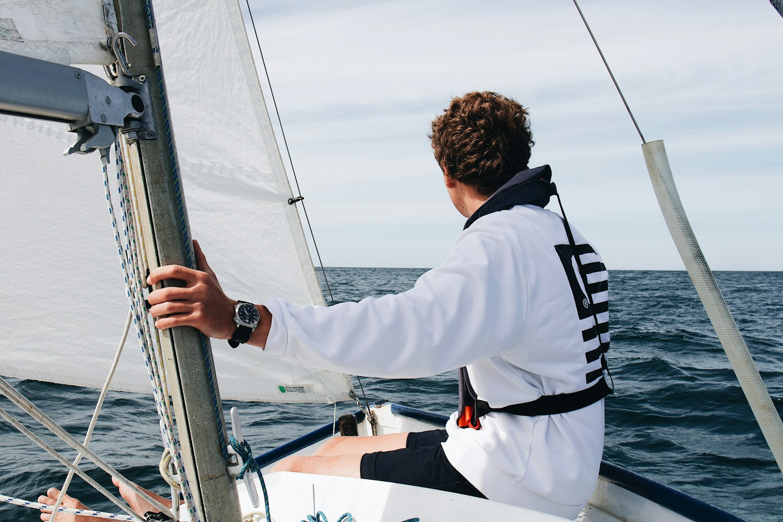man in white and black jacket on white boat during daytime
