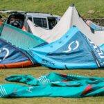 Colorful kite surfing gear laid out on a grassy field ready for adventure. Explaining kitesurf terms