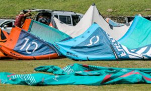Colorful kite surfing gear laid out on a grassy field ready for adventure. Explaining kitesurf terms